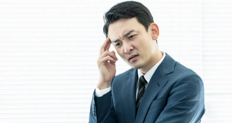 スーツ姿の男性が困っている画像